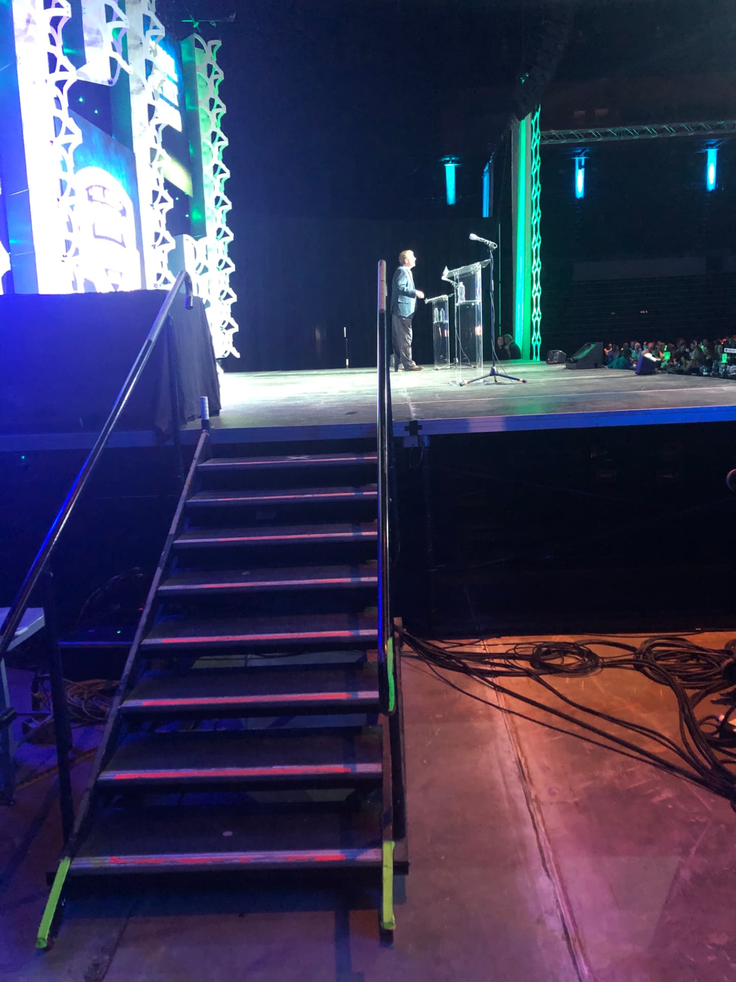 A speaker on a lit stage during a live production