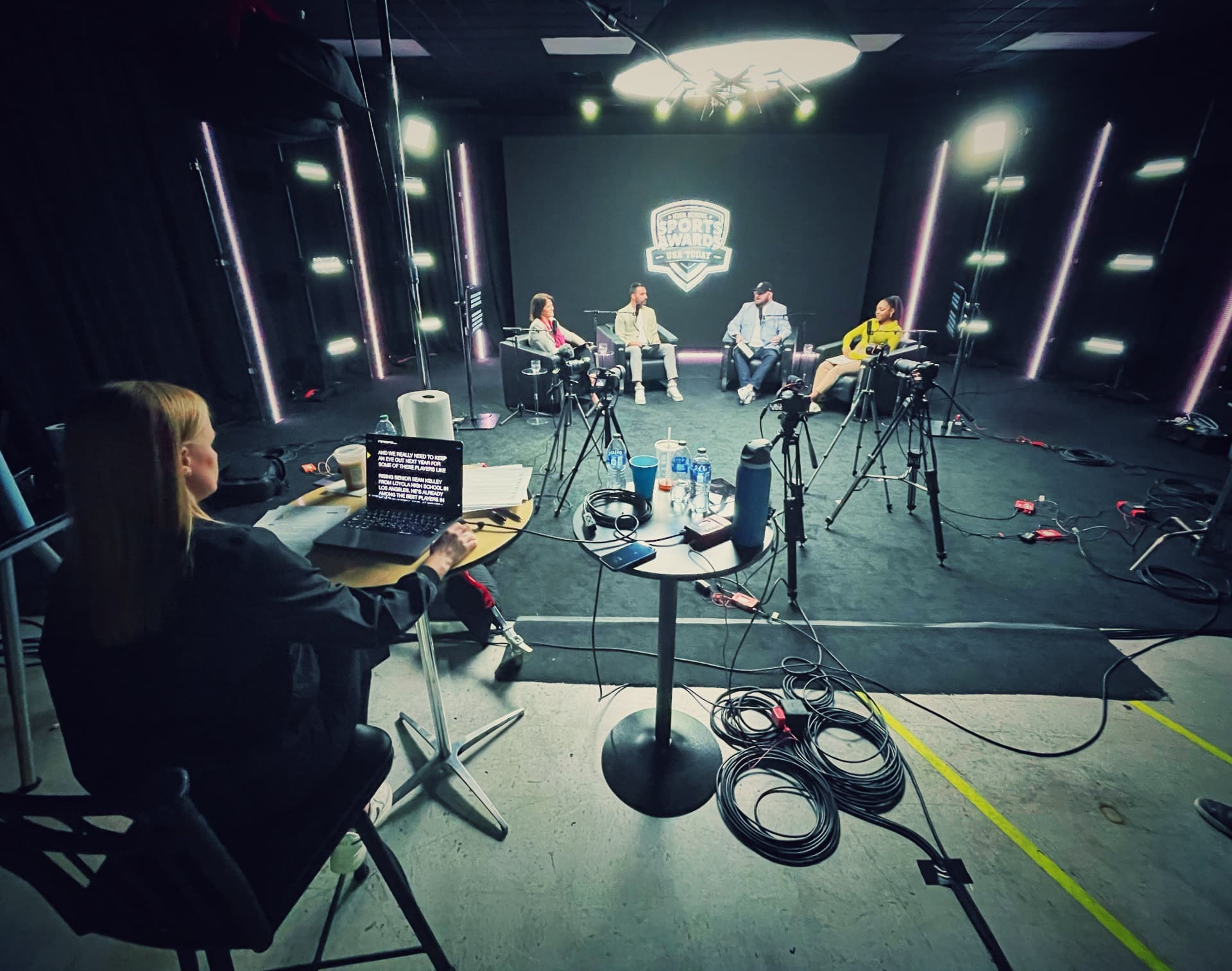 A broadcast set with panelists and cameras