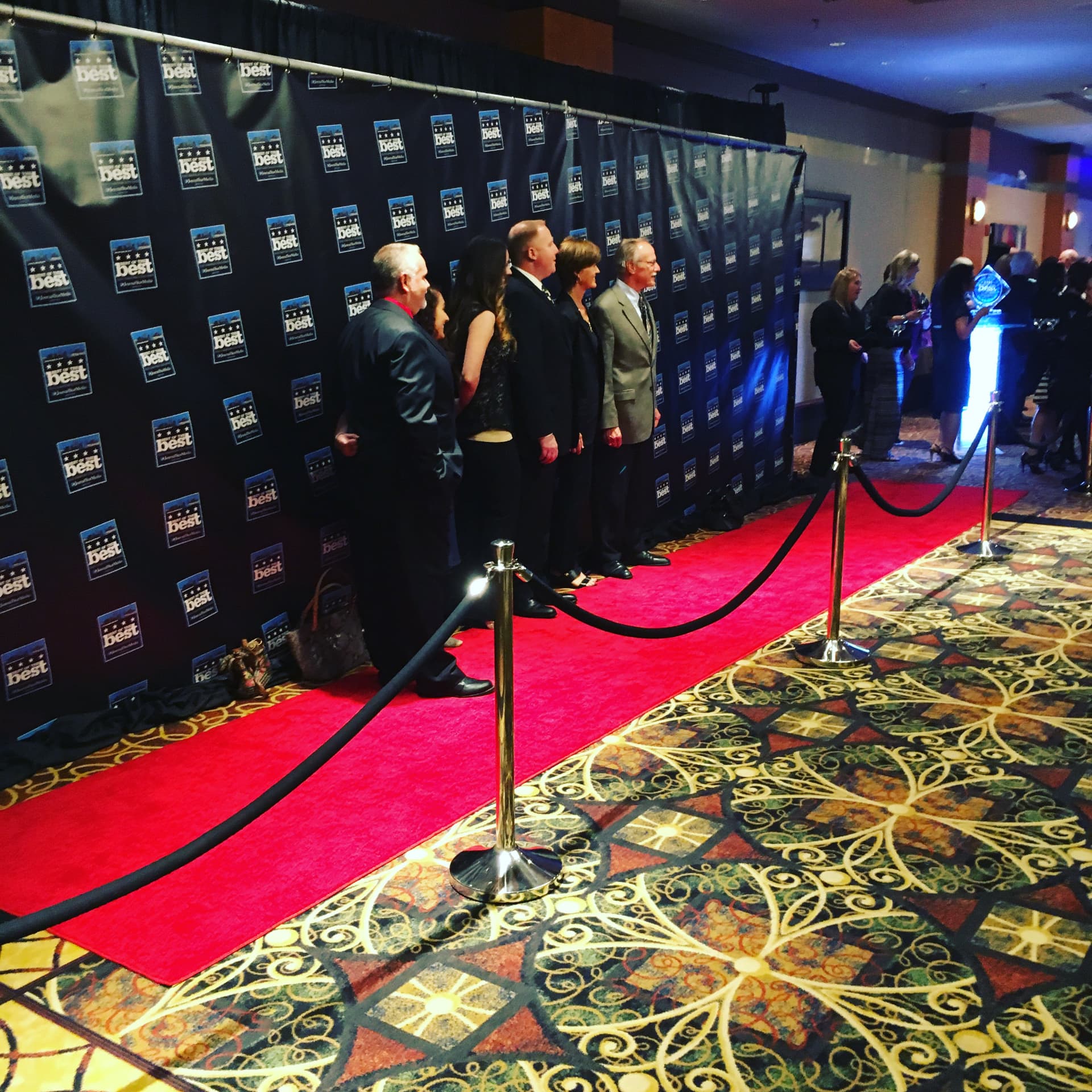 A group posing at a step and repeat backdrop