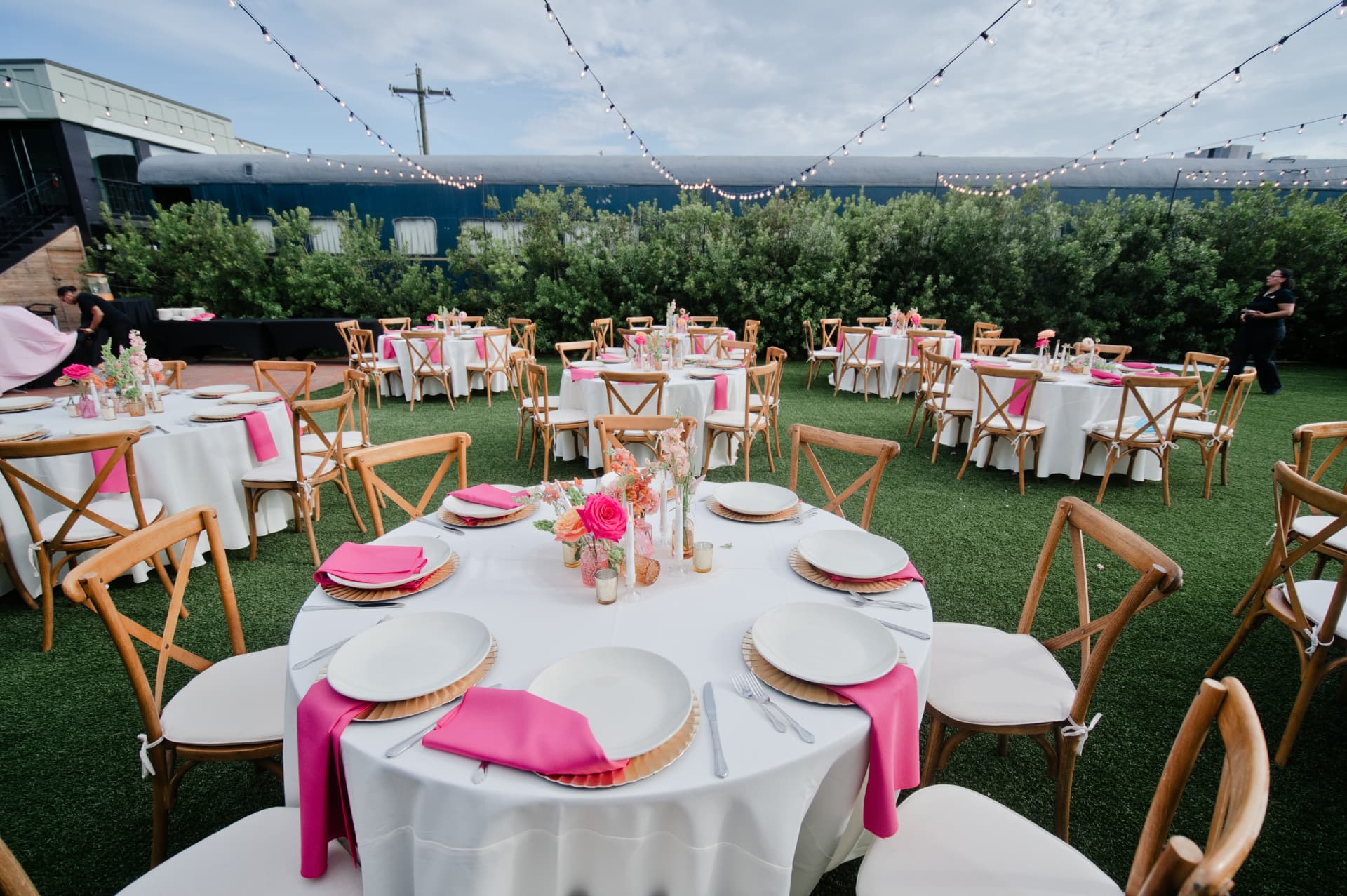 Outdoor reception tables set with bright napkins