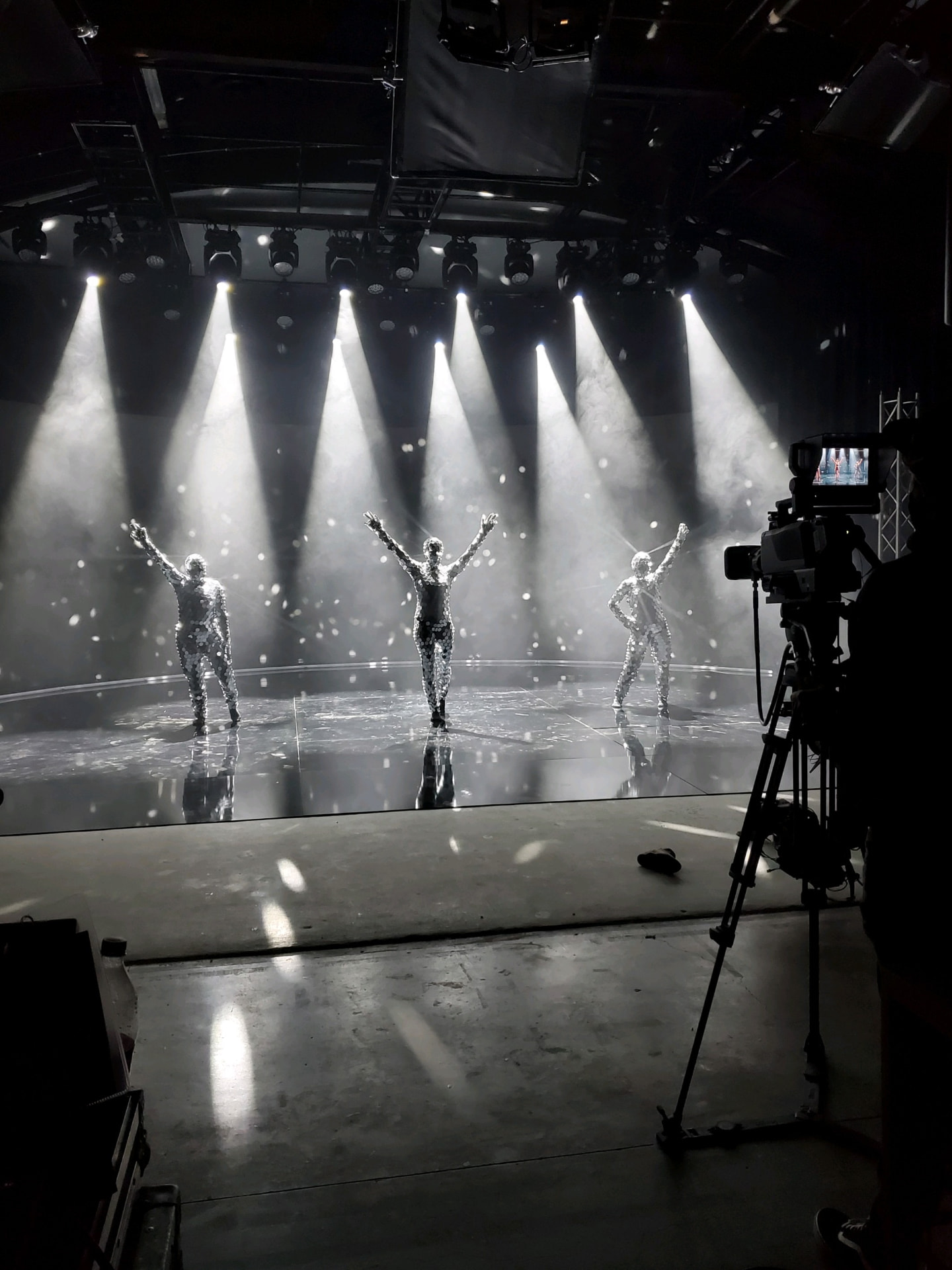 A black and white stage performance with spotlights