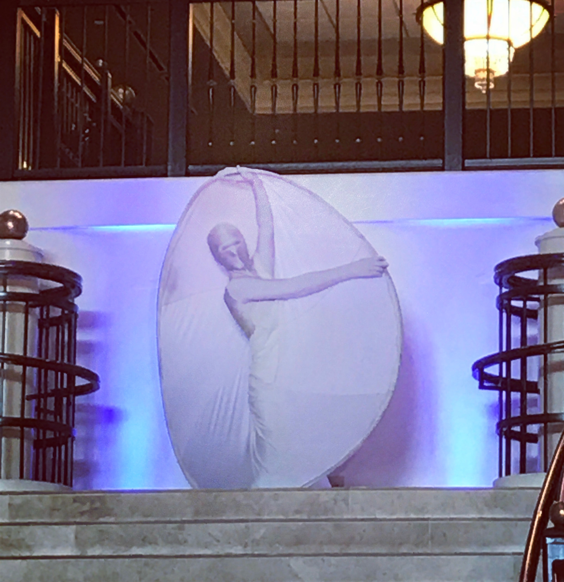 An illuminated performer inside a large sphere