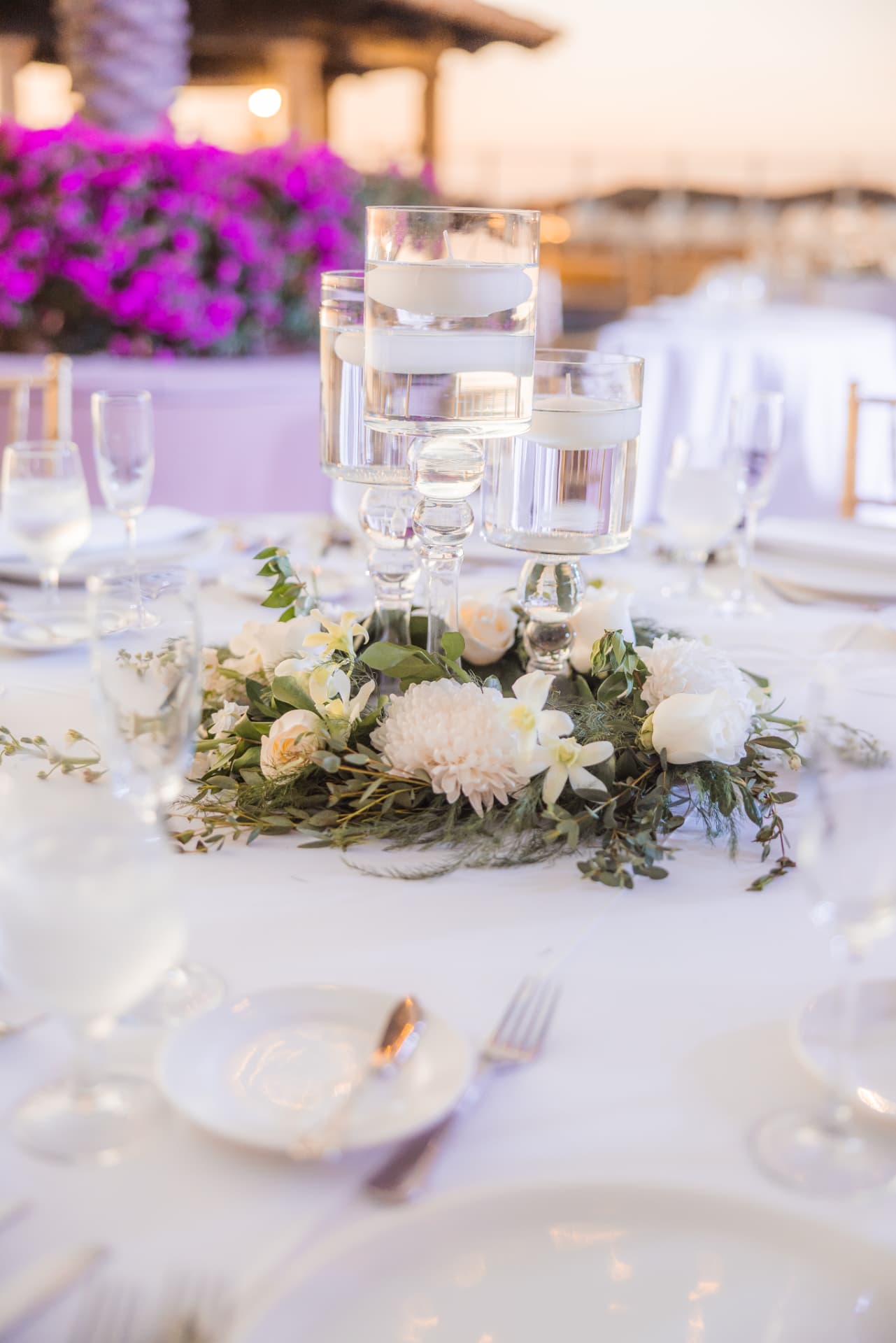 A white and green centerpiece with floating candles